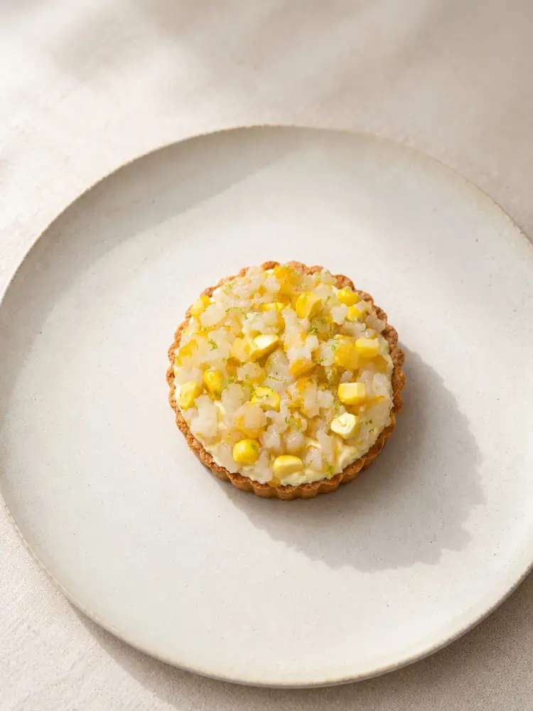 Tartelette à la garniture jaune sur une assiette claire